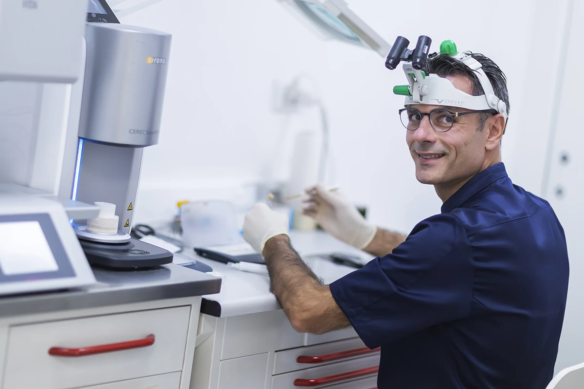 Dottor Giuliodori 
                prepara una protesi dentaria su un tavolo operatorio, con strumenti odontoiatrici e materiali 
                protesici ben organizzati.